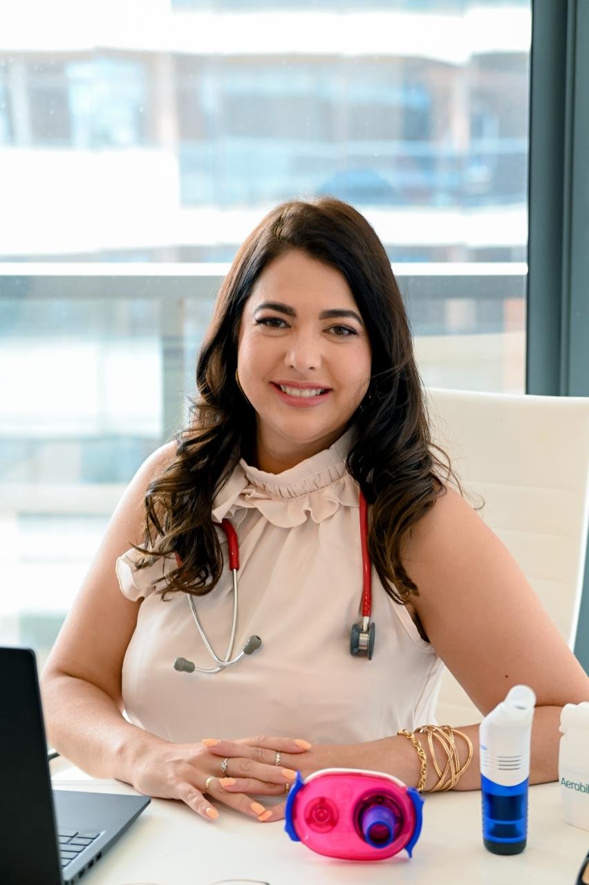 Dra. Andressa com estetoscópio e dispositivos de fisioterapia respiratória