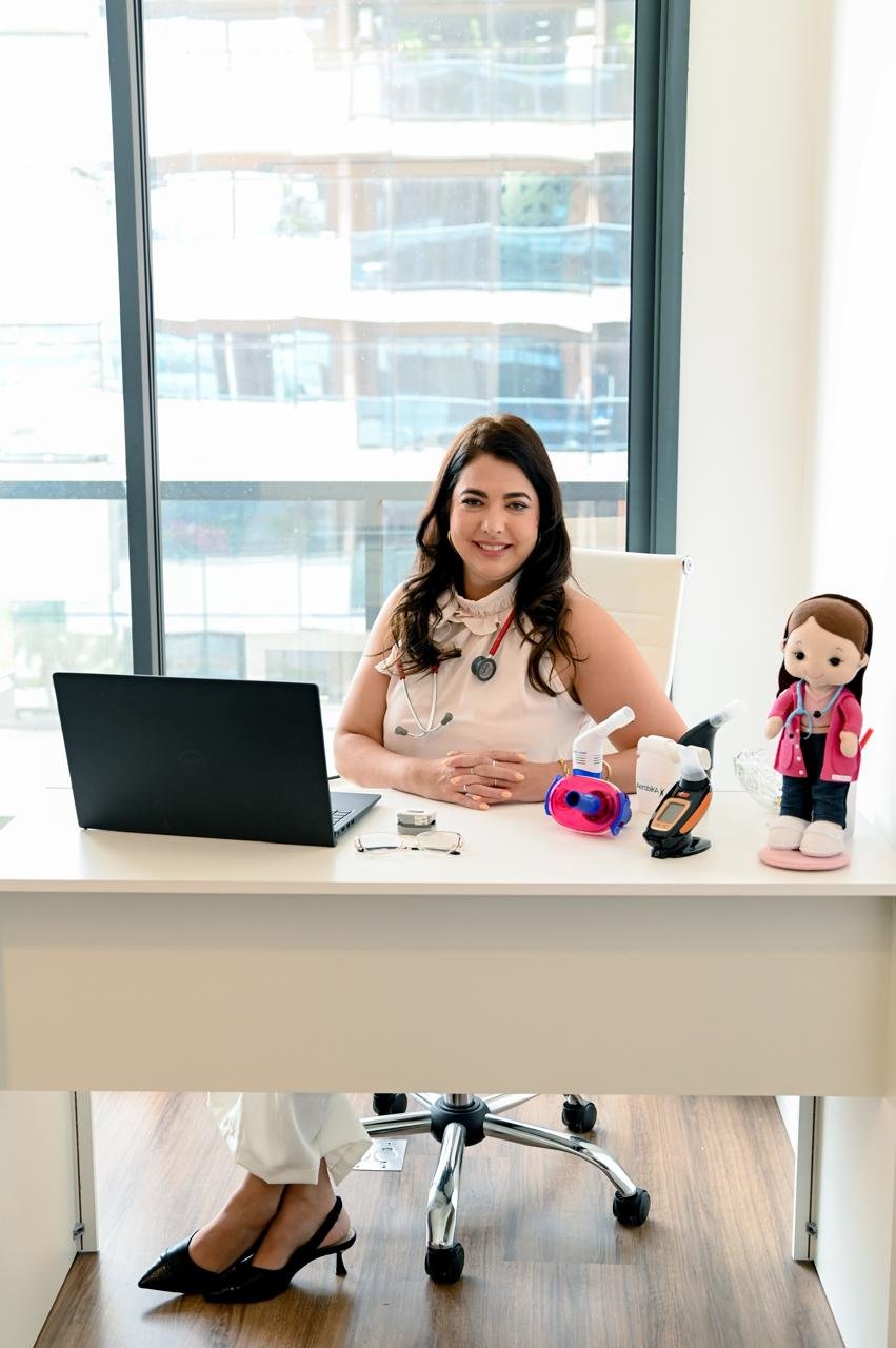 Dra. Andressa em seu consultório com equipamentos respiratórios